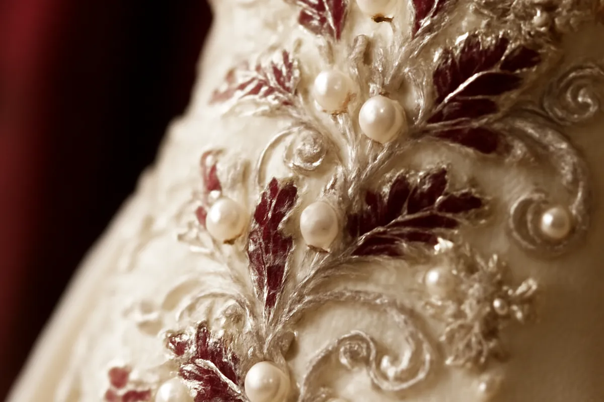 Brodeuse d'atelier haute couture travaillant sur une robe de mariée
